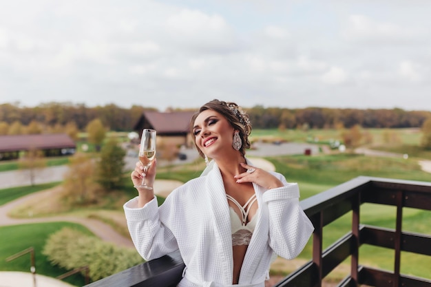 Femme sexy avec un verre de boisson touche son cou