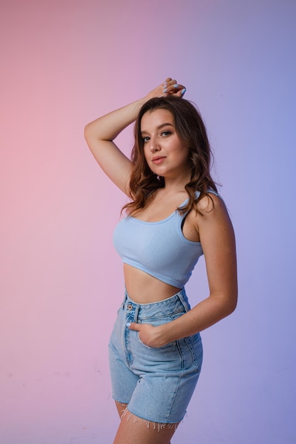 Une femme en short en jean lunettes de soleil en studio sur un beau fond intéressant