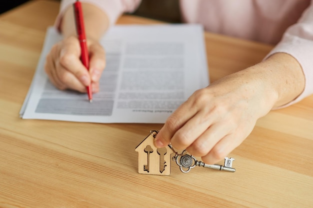 La femme signe les documents Détient la clé de l'appartement Le concept de logement locatif hypothécaire