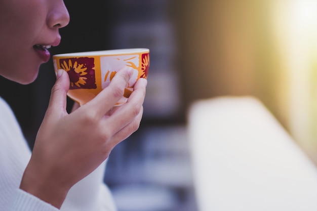 Femme sirotant un café dans le jardin