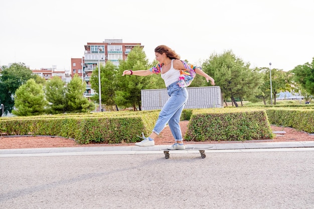 Une femme sur un skateboard dans le concept de Rush brise les règles Une jeune femme active sur un skataboard en ville