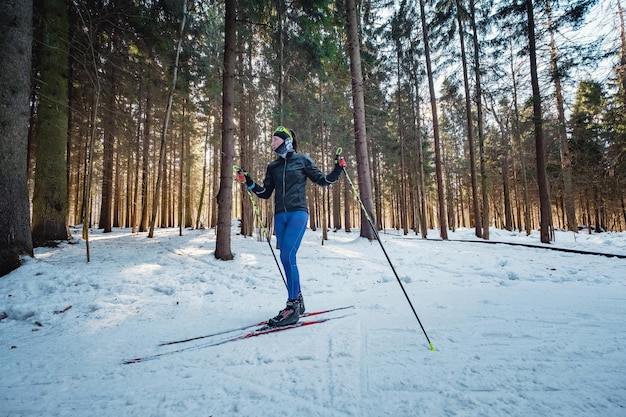 Femme de ski de fond faisant du ski de fond nordique classique sur des pistes dans la forêt couverte de neige Piste d'entraînement pour les skieurs dans le parc de Moscou Odintsovo