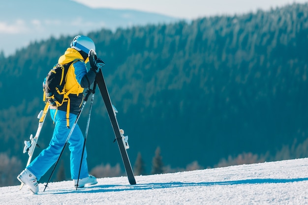 Femme ski vers le bas par des montagnes de pente d'hiver sur l'arrière-plan