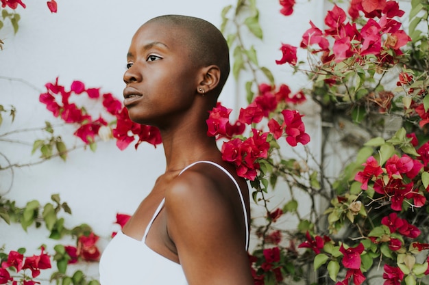 Femme skinhead entourée de fleurs rouges