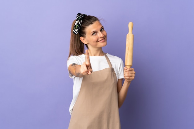 Femme slovaque cuisinière isolée sur fond violet montrant et levant un doigt