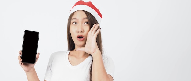 Femme et smartphone. Femme asiatique avec un smartphone à la main qui pose comme un selfie ou un appel vidéo pour une célébration en ligne pendant la saison des festivals de Noël et du nouvel an. Accolades adolescentes heureuses et smartphone.