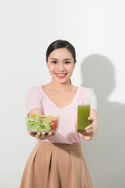 Femme avec des smoothies de désintoxication verts, salade dans un bol en verre isolé. Bonne nutrition, nourriture végétarienne, mode de vie sain, concept de régime. Zone pour copier l'espace