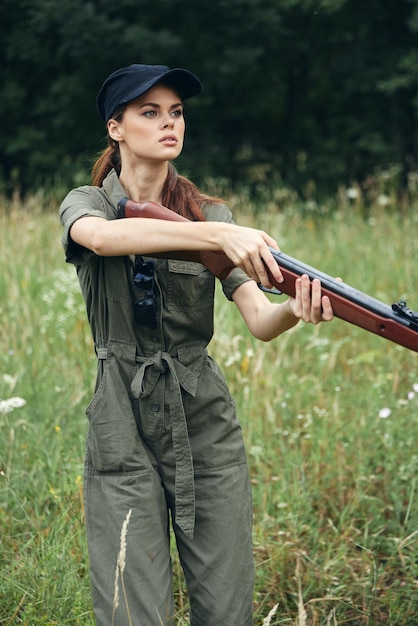 Femme soldat combinaison verte bras entre les mains d'armes de style de vie vert