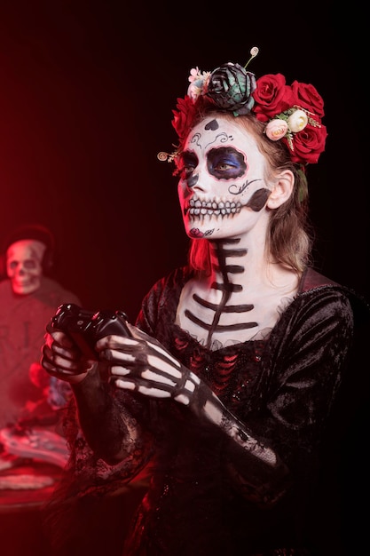 Une femme sombre jouant à des jeux vidéo avec un contrôleur pendant le Dia de los Muertos