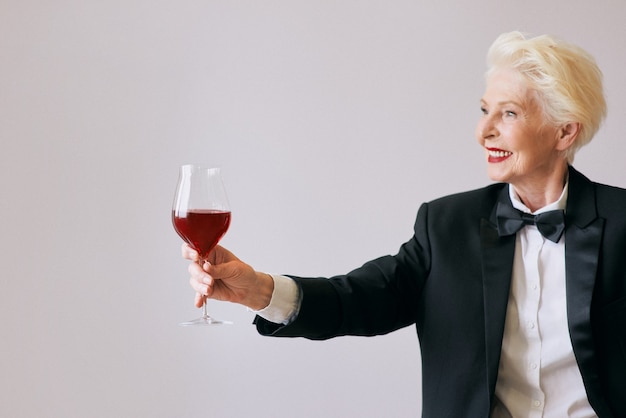 femme sommelier senior en smoking avec verre ou vin rouge