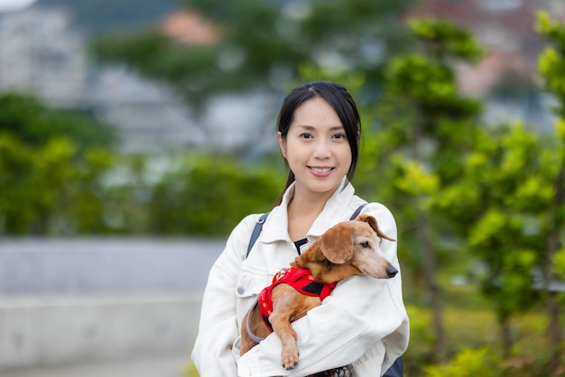 Une femme avec son chien dachshund dans le parc