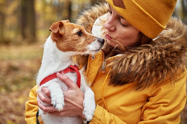 Photo femme avec son chien dans le parc d'automne