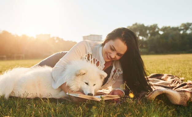 Une femme avec son chien s'amuse sur le terrain pendant la journée ensoleillée