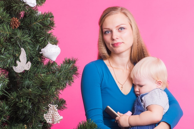 Femme et son enfant posant à côté de l'arbre de Noël