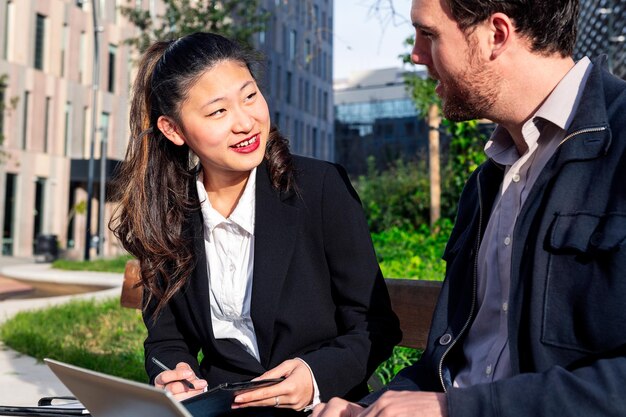 Femme avec son partenaire d'affaires travaillant dans un parc