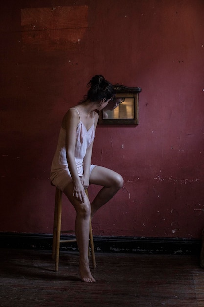 Femme avec son reflet dans le miroir assise à la maison