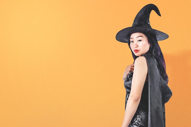 Femme sorcière asiatique avec un chapeau debout