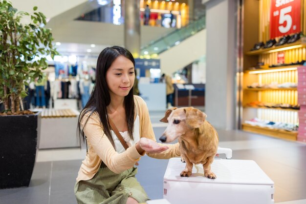 Une femme sort avec son chien dachshund au centre commercial.