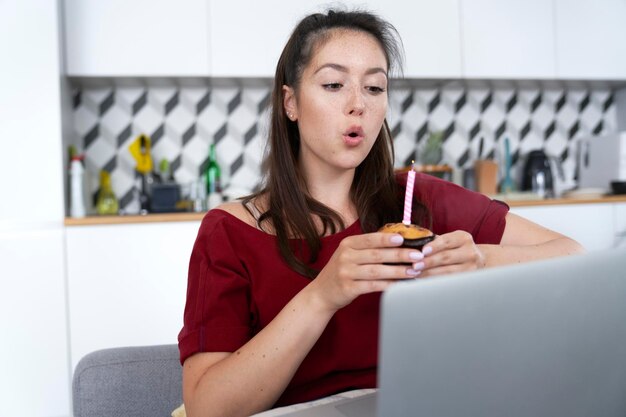 Femme soufflant une bougie d'anniversaire dans la solitude