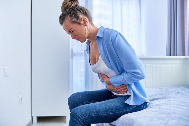Femme souffrant de forts maux d'estomac lors d'un ulcère gastrique