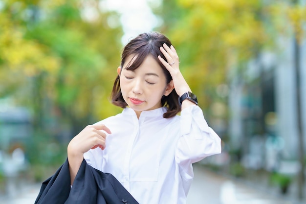 Une femme souffrant d'un mal de tête dans la rue