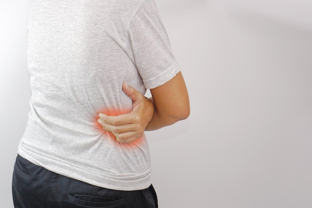 Femme souffrant de maux de dos à la taille ou de douleurs à la hanche. Syndrome de bureau de mal de dos et concept de santé.