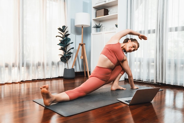 Femme souple et de dexterité en vêtements de sport faisant une position de yoga gaieté inverse