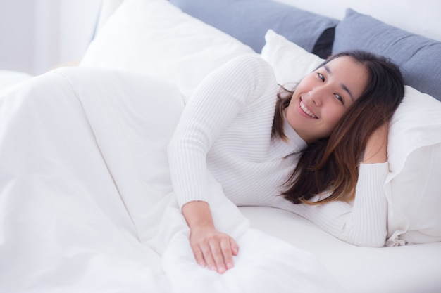 Femme souriant doucement au lit