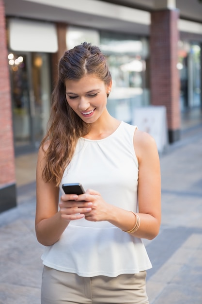 Femme souriante à l&#39;aide de smartphone