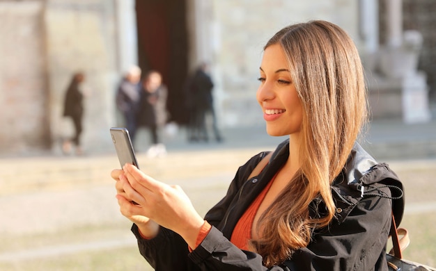 Femme souriante à l'aide de son smartphone