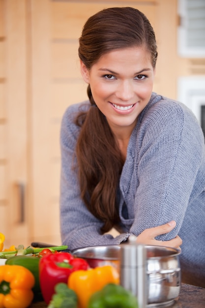 Femme souriante, appuyé contre le comptoir de la cuisine