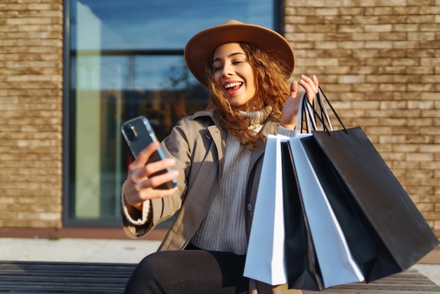 Photo femme souriante après avoir fait du shopping dans la rue de la ville achats concept de vente concept de magasinage en ligne