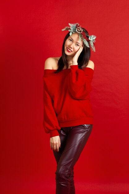 Femme souriante asiatique avec une couronne de Noël