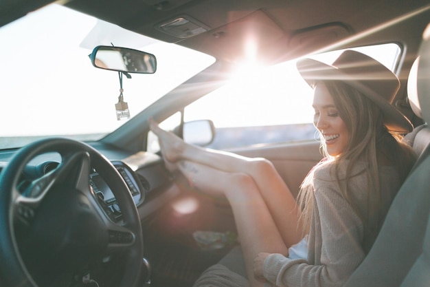 Une femme souriante assise dans la voiture.