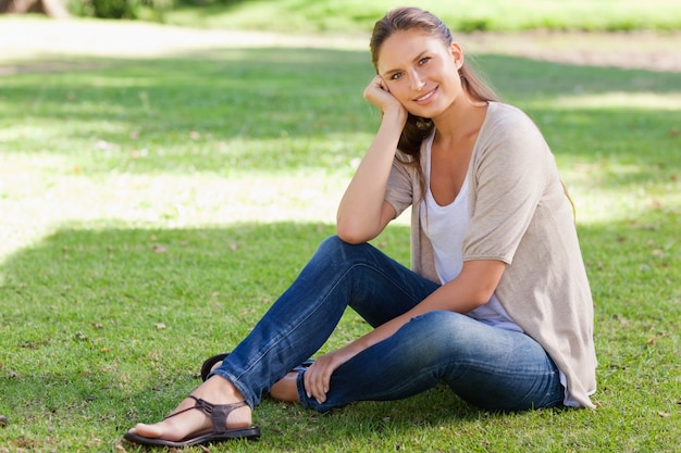 Femme souriante assise sur l&#39;herbe