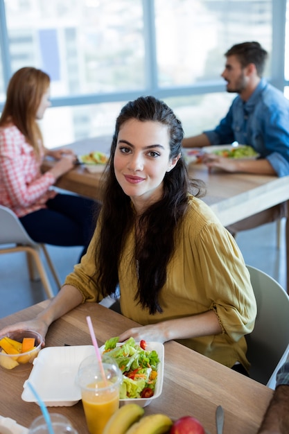 Femme souriante, avoir repas, dans, bureau