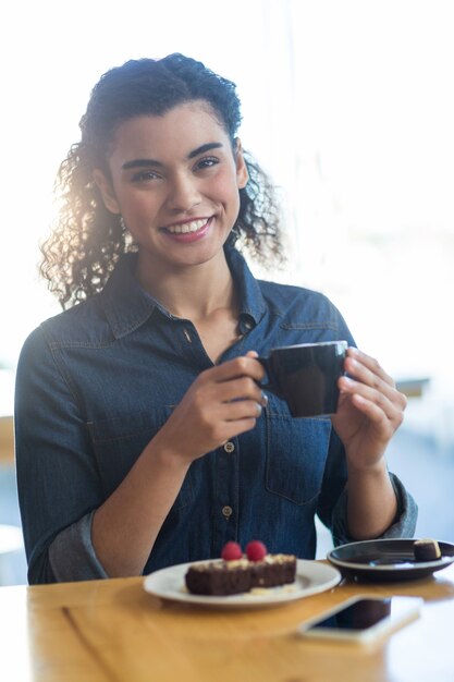 Femme souriante, avoir, a, tasse café, dans, café-restaurant