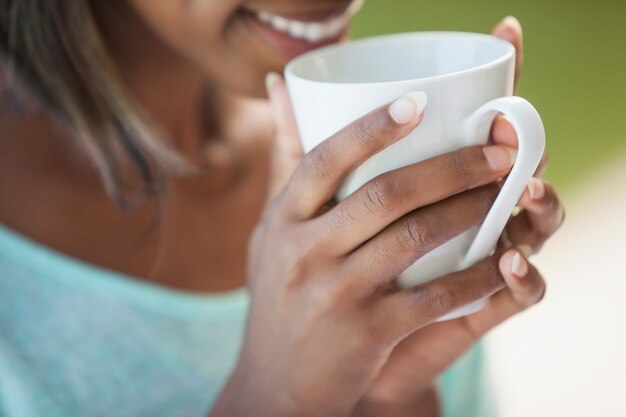 Femme souriante ayant un café à l&#39;extérieur