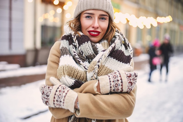 Femme souriante ayant froid le jour de l'hiver à l'extérieur