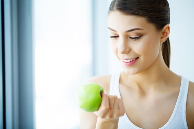 Femme Souriante Avec Un Beau Sourire, Dents Blanches Tenant La Pomme. Image haute résolution