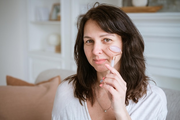 Femme souriante brune de 35 ans plus le visage et les mains frais et propres avec de longs