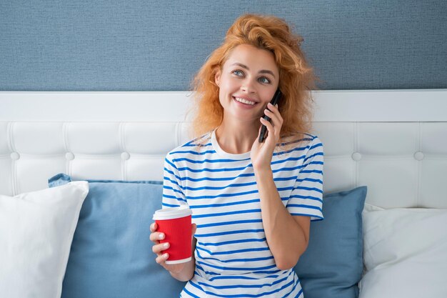 Femme souriante avec café parler au téléphone femme à la maison parler au téléphone parler au téléphone femme