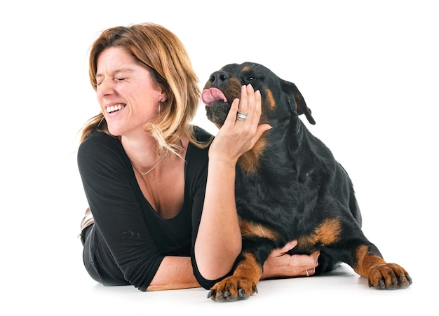 Une femme souriante avec un chien allongé sur un fond blanc