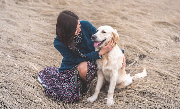 Femme souriante avec un chien mignon sur la nature au début du printemps