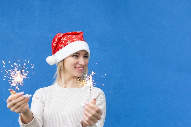 Une femme souriante avec des cierges magiques dans ses mains Portrait Christmas Copy space