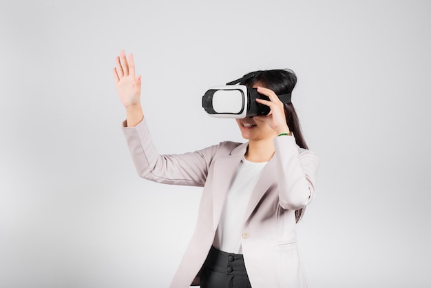 Femme souriante confiante excitée porter un casque VR touchant l'air pendant l'expérience de réalité virtuelle isolé sur fond blanc, asiatique portrait heureux femme jouant au jeu vidéo prise de vue en studio, espace de copie