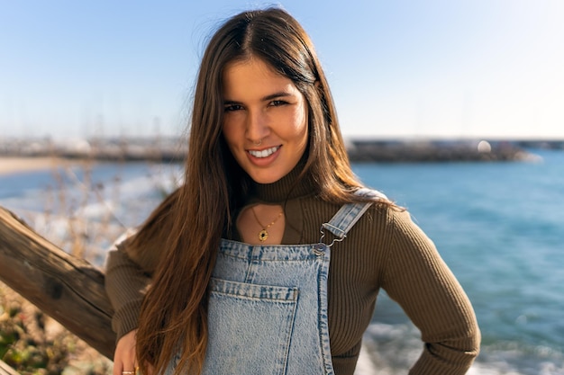 Femme souriante contre la mer aux beaux jours