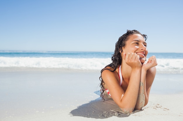 Femme souriante couchée sur la plage