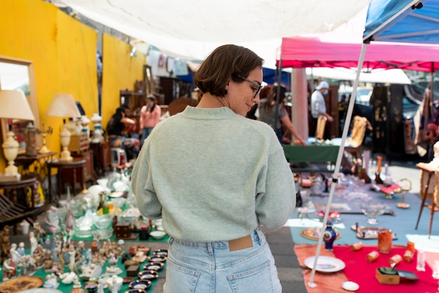 Femme souriante à coup moyen au marché de l'occasion