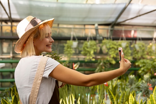 Femme souriante de coup moyen prenant selfie